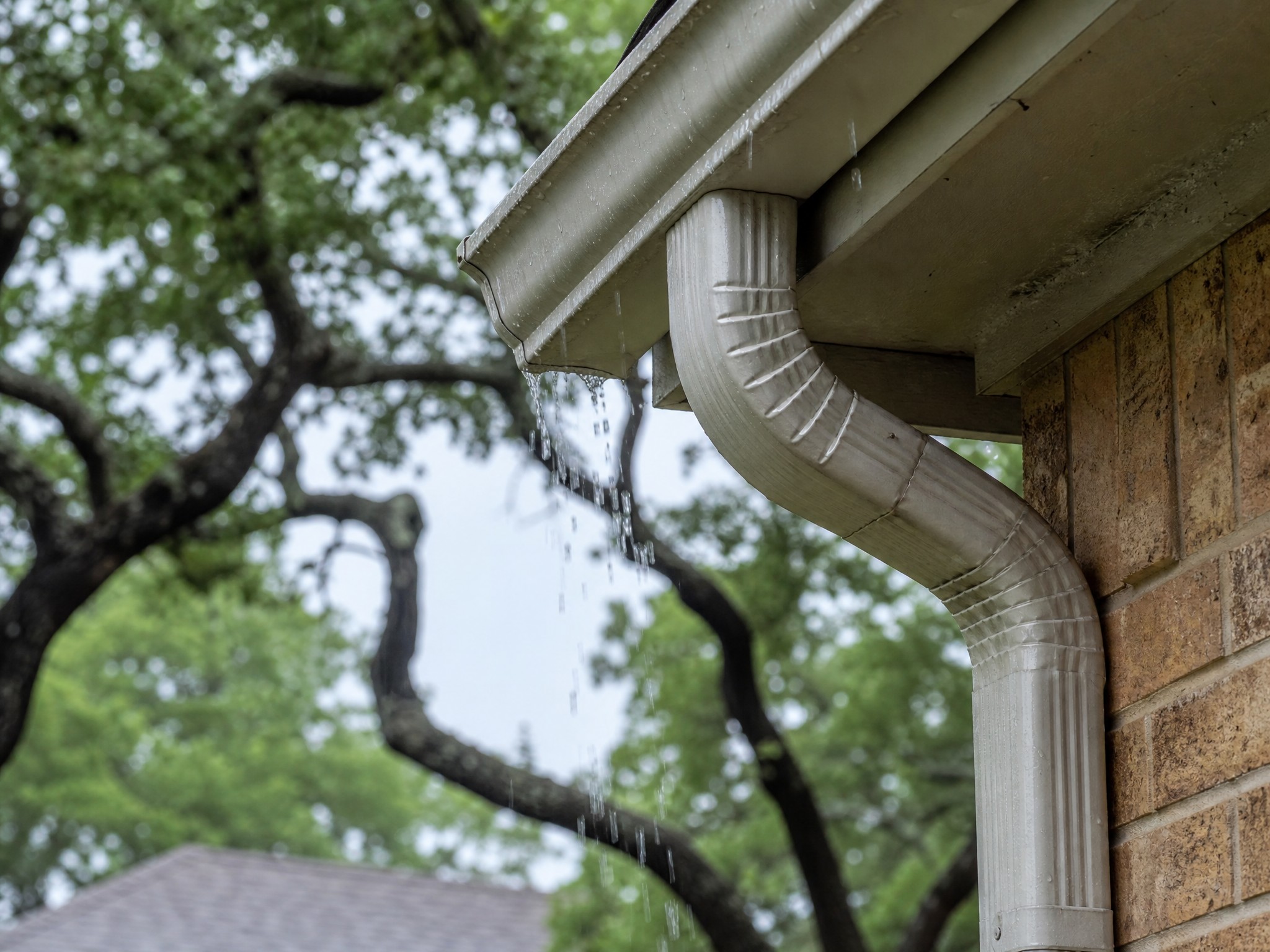 Rain gutters and downspout on a Central Texas brick home