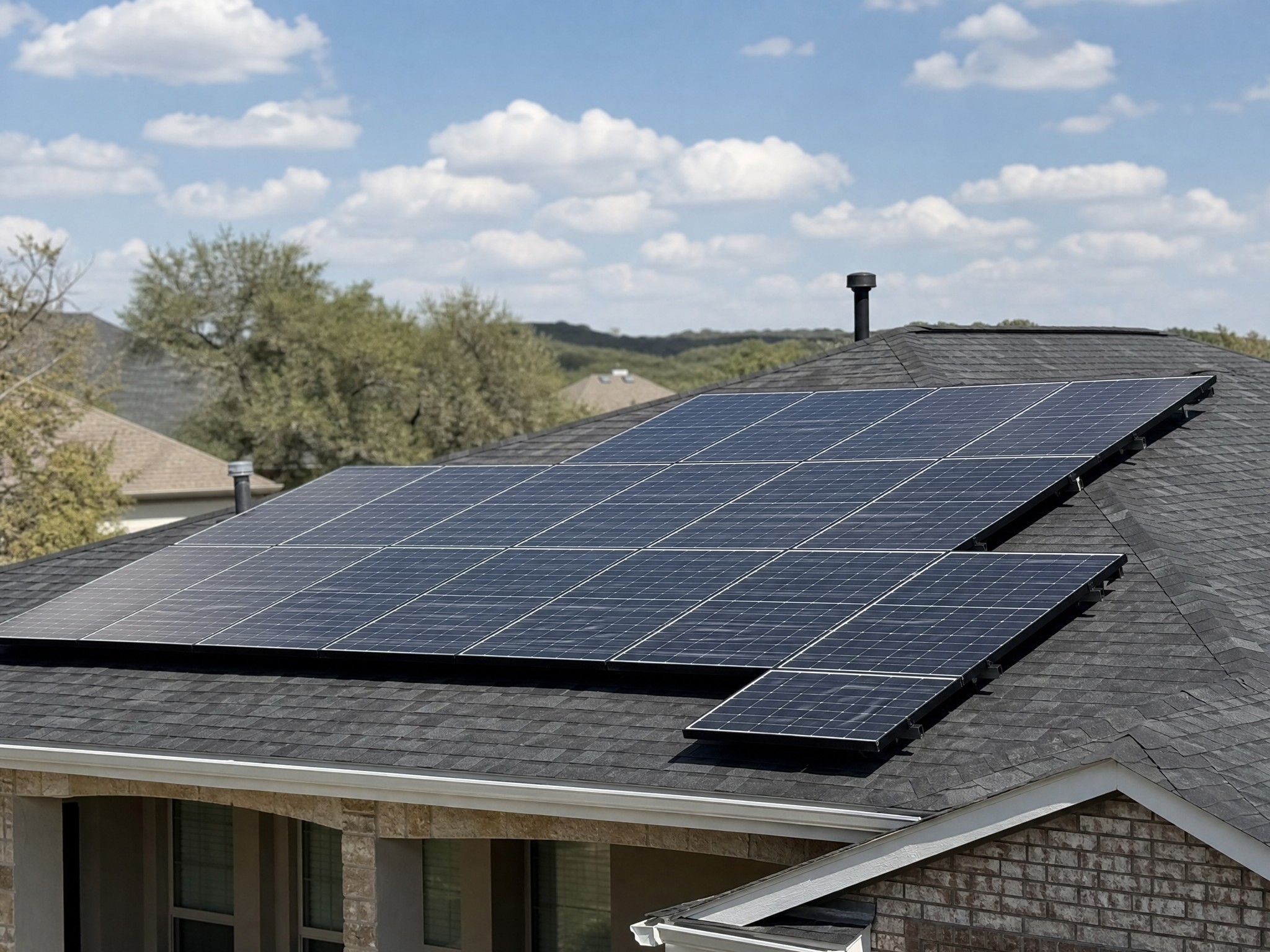 Solar panels mounted on the shingle roof of a Central Texas home