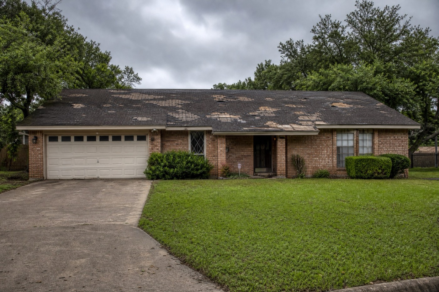 Texas home with an old, storm-damaged shingle roof